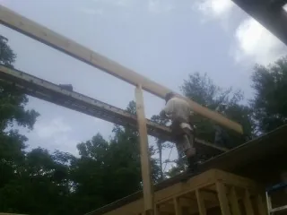 Carpenter setting a ridge beam over a new addition frame — Ice Dam Removal by Roofing Brothers in Ransomville