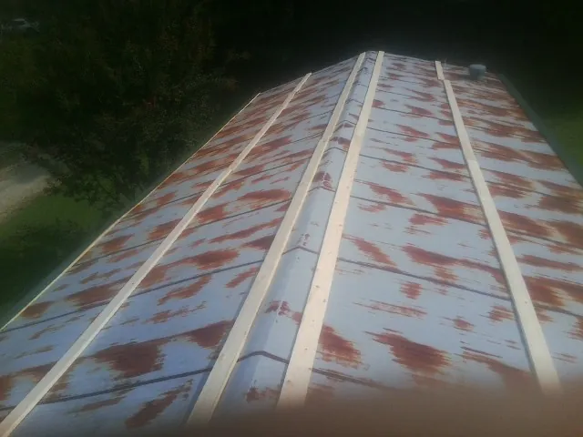 Rusted metal roof panels with new wood purlins before replacement — Storm Damage Roof Repair in Ransomville by Roofing Brothers